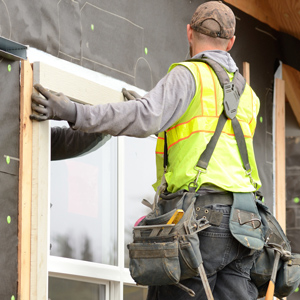 construction worker installing window at jobsite
