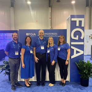 FGIA staff standing in front of booth signage at GlassBuild