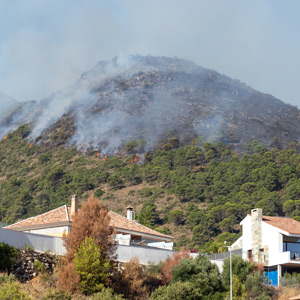 smoke over mountains with homes in the foreground
