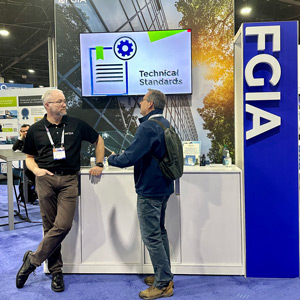 Jason Seals with a visitor in FGIA booth at GlassBuild America 2023